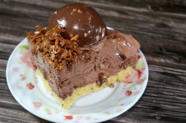 Çikolata topağı ve kremayla kaplı, bir parça dondurmalı pastadan bir parça, ve karamel sosu ve fındıklı çikolata, yaz ve tatil konsepti.