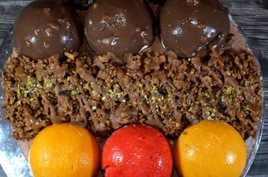 Dondurmalı pasta, üzerinde çikolata topu ve krema, karamel sosu, fındıklı çikolata parçaları, fındık, mango ve çilek topları, yaz ve tatil konsepti.