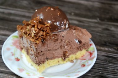 Çikolata topağı ve kremayla kaplı, bir parça dondurmalı pastadan bir parça, ve karamel sosu ve fındıklı çikolata, yaz ve tatil konsepti.