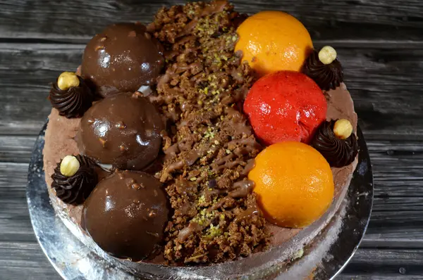 Dondurmalı pasta, üzerinde çikolata topu ve krema, karamel sosu, fındıklı çikolata parçaları, fındık, mango ve çilek topları, yaz ve tatil konsepti.