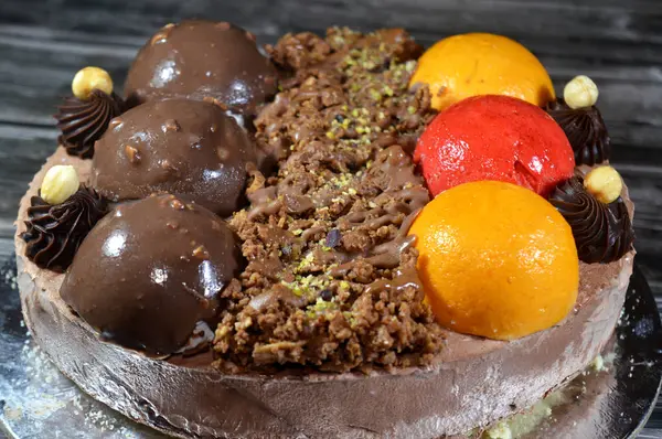 Dondurmalı pasta, üzerinde çikolata topu ve krema, karamel sosu, fındıklı çikolata parçaları, fındık, mango ve çilek topları, yaz ve tatil konsepti.