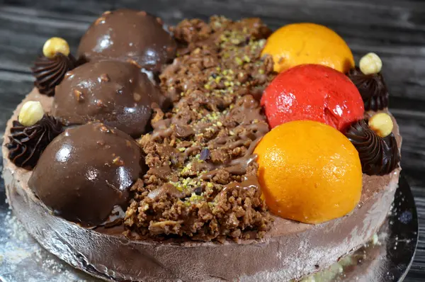 Dondurmalı pasta, üzerinde çikolata topu ve krema, karamel sosu, fındıklı çikolata parçaları, fındık, mango ve çilek topları, yaz ve tatil konsepti.