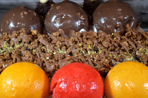 Dondurmalı pasta, üzerinde çikolata topu ve krema, karamel sosu, fındıklı çikolata parçaları, fındık, mango ve çilek topları, yaz ve tatil konsepti.