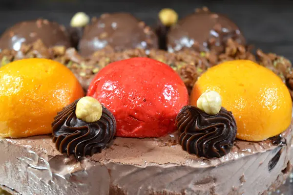 Dondurmalı pasta, üzerinde çikolata topu ve krema, karamel sosu, fındıklı çikolata parçaları, fındık, mango ve çilek topları, yaz ve tatil konsepti.