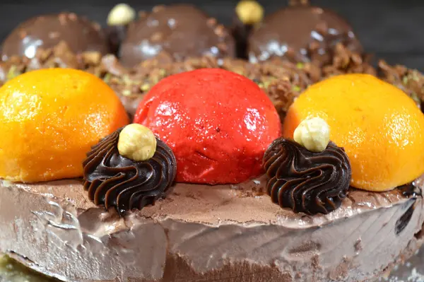 Dondurmalı pasta, üzerinde çikolata topu ve krema, karamel sosu, fındıklı çikolata parçaları, fındık, mango ve çilek topları, yaz ve tatil konsepti.