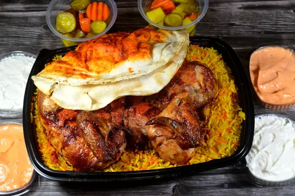 Nemli ve sulu Halep Arap mutfağından ızgara ızgara ızgara tavuk renkli Basmati pilavı, ızgara tavuk ızgara makinesinde ızgara edilmiş tavuk, sarımsak sosu ve turşu.