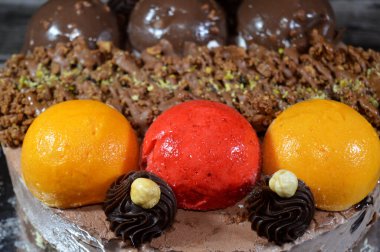 Dondurmalı pasta, üzerinde çikolata topu ve krema, karamel sosu, fındıklı çikolata parçaları, fındık, mango ve çilek topları, yaz ve tatil konsepti.