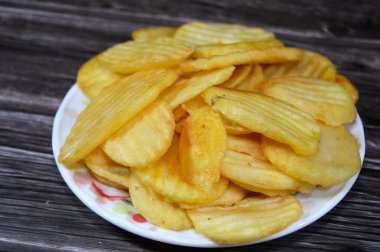 Patates cipsi, cips, ince patates dilimleri, kızartılmış, pişirilmiş, veya kızarana kadar havada kızartılmış, aperatif, meze veya meze olarak servis edilmiş, temel cips pişti ve tuzlandı, bazıları diğer tatlarla birlikte.