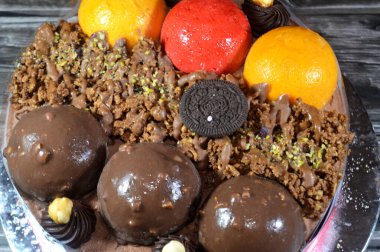 Kahire, Mısır, Haziran 12025: Kremalı pasta, üzerinde Oreo, çikolata topları ve krema, fındık ve karamel sosu ve çikolata, fındık, çilek ve mango topları var.