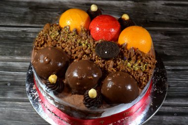 Kahire, Mısır, Haziran 12025: Kremalı pasta, üzerinde Oreo, çikolata topları ve krema, fındık ve karamel sosu ve çikolata, fındık, çilek ve mango topları var.