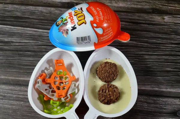 Kahire, Mısır, Haziran 12025 Kinder Joy çikolata yumurtası, iki mühürlü yumurta şeklinde plastik bir paket. Bir yarısı kremalı dolgu içerirken, diğer yarısı bir oyuncak içeriyor.