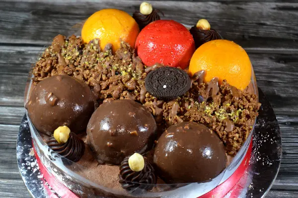 Kahire, Mısır, Haziran 12025: Kremalı pasta, üzerinde Oreo, çikolata topları ve krema, fındık ve karamel sosu ve çikolata, fındık, çilek ve mango topları var.