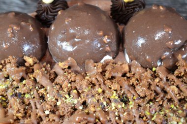 Çikolatalı kek, üzerinde çikolata topu ve krema, ve karamel sosu ve çikolata parçacıkları ile kaplı fındık, yaz ve tatil konsepti.