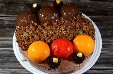 Dondurmalı pasta, üzerinde çikolata topu ve krema, karamel sosu, fındıklı çikolata parçaları, fındık, mango ve çilek topları, yaz ve tatil konsepti.