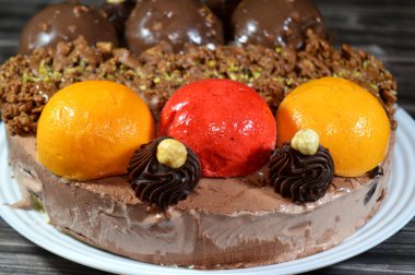 Dondurmalı pasta, üzerinde çikolata topu ve krema, karamel sosu, fındıklı çikolata parçaları, fındık, mango ve çilek topları, yaz ve tatil konsepti.