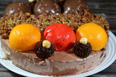 Dondurmalı pasta, üzerinde çikolata topu ve krema, karamel sosu, fındıklı çikolata parçaları, fındık, mango ve çilek topları, yaz ve tatil konsepti.