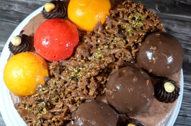 Dondurmalı pasta, üzerinde çikolata topu ve krema, karamel sosu, fındıklı çikolata parçaları, fındık, mango ve çilek topları, yaz ve tatil konsepti.