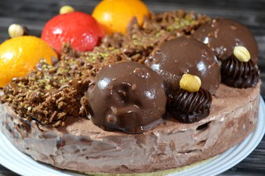 Dondurmalı pasta, üzerinde çikolata topu ve krema, karamel sosu, fındıklı çikolata parçaları, fındık, mango ve çilek topları, yaz ve tatil konsepti.