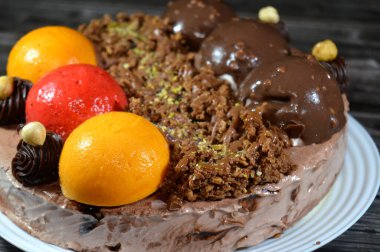 Dondurmalı pasta, üzerinde çikolata topu ve krema, karamel sosu, fındıklı çikolata parçaları, fındık, mango ve çilek topları, yaz ve tatil konsepti.