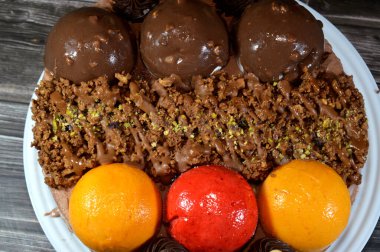 Dondurmalı pasta, üzerinde çikolata topu ve krema, karamel sosu, fındıklı çikolata parçaları, fındık, mango ve çilek topları, yaz ve tatil konsepti.