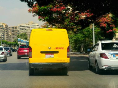 Kahire, Mısır, 31 Mayıs 2025: DHL minibüs bir paket teslimatı yapıyor, DHL uluslararası nakliye, kurye hizmetleri ve taşımacılık alanında uzmanlaşmış lojistik sektöründe küresel lider.