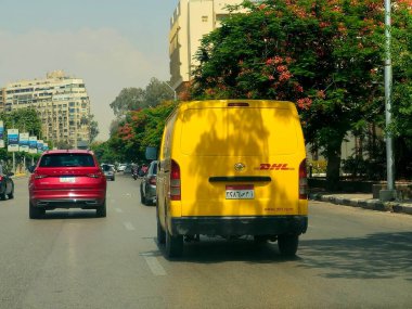 Kahire, Mısır, 31 Mayıs 2025: DHL minibüs bir paket teslimatı yapıyor, DHL uluslararası nakliye, kurye hizmetleri ve taşımacılık alanında uzmanlaşmış lojistik sektöründe küresel lider.