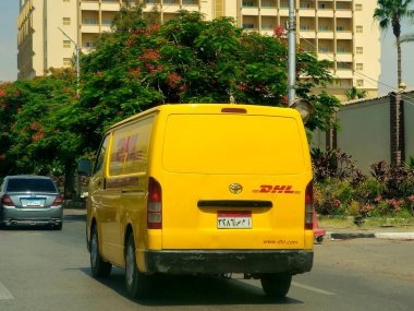 Kahire, Mısır, 31 Mayıs 2025: DHL minibüs bir paket teslimatı yapıyor, DHL uluslararası nakliye, kurye hizmetleri ve taşımacılık alanında uzmanlaşmış lojistik sektöründe küresel lider.