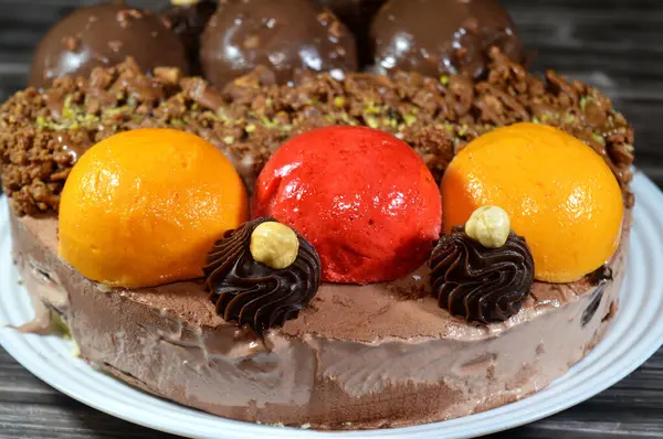 Dondurmalı pasta, üzerinde çikolata topu ve krema, karamel sosu, fındıklı çikolata parçaları, fındık, mango ve çilek topları, yaz ve tatil konsepti.