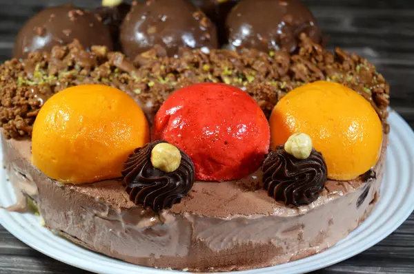 Dondurmalı pasta, üzerinde çikolata topu ve krema, karamel sosu, fındıklı çikolata parçaları, fındık, mango ve çilek topları, yaz ve tatil konsepti.