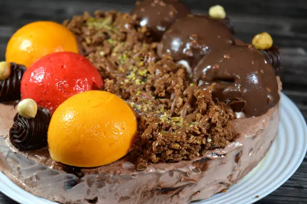 Dondurmalı pasta, üzerinde çikolata topu ve krema, karamel sosu, fındıklı çikolata parçaları, fındık, mango ve çilek topları, yaz ve tatil konsepti.
