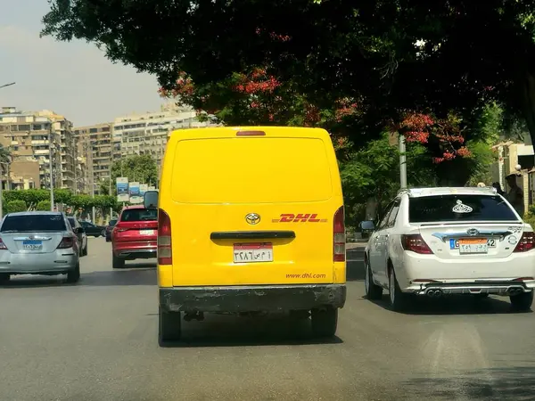 Kahire, Mısır, 31 Mayıs 2025: DHL minibüs bir paket teslimatı yapıyor, DHL uluslararası nakliye, kurye hizmetleri ve taşımacılık alanında uzmanlaşmış lojistik sektöründe küresel lider.