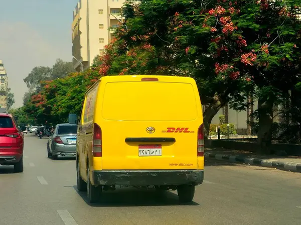 Kahire, Mısır, 31 Mayıs 2025: DHL minibüs bir paket teslimatı yapıyor, DHL uluslararası nakliye, kurye hizmetleri ve taşımacılık alanında uzmanlaşmış lojistik sektöründe küresel lider.