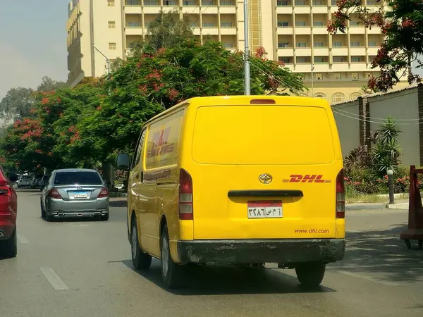 Kahire, Mısır, 31 Mayıs 2025: DHL minibüs bir paket teslimatı yapıyor, DHL uluslararası nakliye, kurye hizmetleri ve taşımacılık alanında uzmanlaşmış lojistik sektöründe küresel lider.