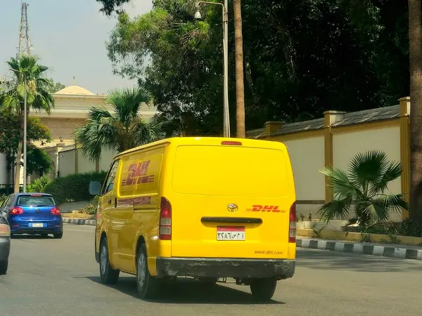 Kahire, Mısır, 31 Mayıs 2025: DHL minibüs bir paket teslimatı yapıyor, DHL uluslararası nakliye, kurye hizmetleri ve taşımacılık alanında uzmanlaşmış lojistik sektöründe küresel lider.