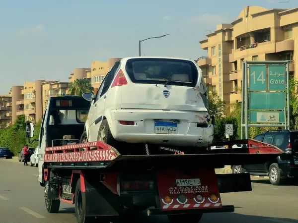 Kahire, Mısır, 30 Mayıs 2025: Çekici kurtarma taşıyıcısı hidrolik kamyon bozuk bir arabayı kaldırıyor, bakım hizmetleri için sokaktan bir arabayı kurtarıyor