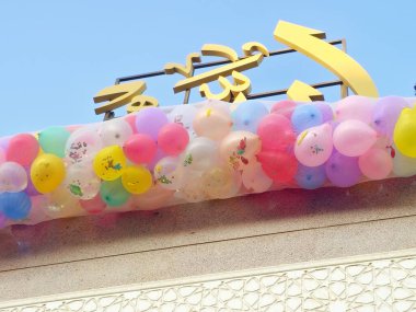 Arapça metnin çevirisi (Allah, Tanrı), Kahire 'de bir camide bayram kutlamaları, minarenin yanındaki caminin çatısında onlarca balon, Kurban Bayramı' nda çocuklara atılacak.