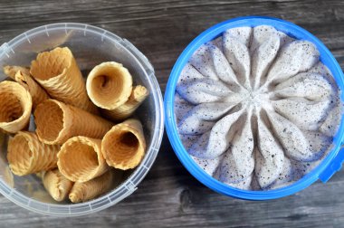 Kurabiye parçalı vanilyalı beyaz dondurma, çiçek şeklinde kurabiyeli vanilyalı dondurma ve dondurma külahları, dondurma için waffle bisküvileri, yaz konsepti.