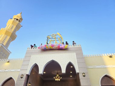 Kahire, Mısır, 6 Haziran 2025: Camide çocuklarla kutlama hazırlığı, balonlar atmak, bayram kutlamaları düzenlemek, Kurban Bayramı, Khutbah (vaaz) ve dua etmek, şeker vermek