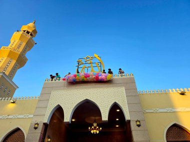 Kahire, Mısır, 6 Haziran 2025: Camide çocuklarla kutlama hazırlığı, balonlar atmak, bayram kutlamaları düzenlemek, Kurban Bayramı, Khutbah (vaaz) ve dua etmek, şeker vermek