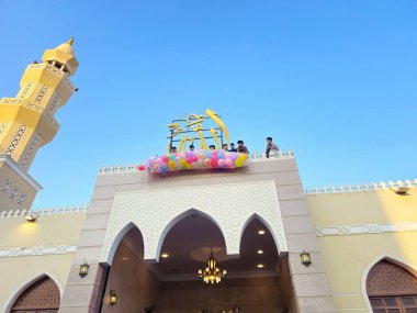 Kahire, Mısır, 6 Haziran 2025: Camide çocuklarla kutlama hazırlığı, balonlar atmak, bayram kutlamaları düzenlemek, Kurban Bayramı, Khutbah (vaaz) ve dua etmek, şeker vermek