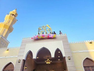 Kahire, Mısır, 6 Haziran 2025: Camide çocuklarla kutlama hazırlığı, balonlar atmak, bayram kutlamaları düzenlemek, Kurban Bayramı, Khutbah (vaaz) ve dua etmek, şeker vermek