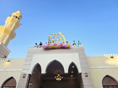 Kahire, Mısır, 6 Haziran 2025: Camide çocuklarla kutlama hazırlığı, balonlar atmak, bayram kutlamaları düzenlemek, Kurban Bayramı, Khutbah (vaaz) ve dua etmek, şeker vermek
