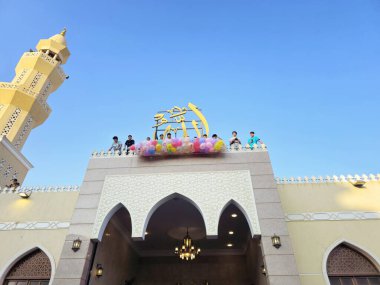 Kahire, Mısır, 6 Haziran 2025: Camide çocuklarla kutlama hazırlığı, balonlar atmak, bayram kutlamaları düzenlemek, Kurban Bayramı, Khutbah (vaaz) ve dua etmek, şeker vermek