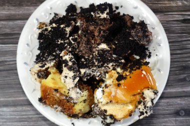 Bir tabak dolusu peynirli kek ile samur bisküvisi Fransız kurabiyesi kremalı çikolata ve bisküvi kremalı pasta, kremalı krema, çikolata soslu, sütlü kek.