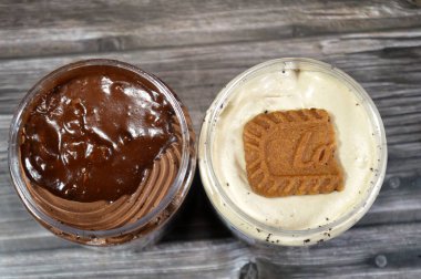 Kahire, Mısır, 8 Haziran 2025: Kremalı çikolata ve nilüfer bisküvisi üzerine çikolata sosu, bisküvi ve çikolatalı pasta ve Rocher katmanlı krema, hava kabarcıkları ile hazırlanmış yumuşak bir yemektir
