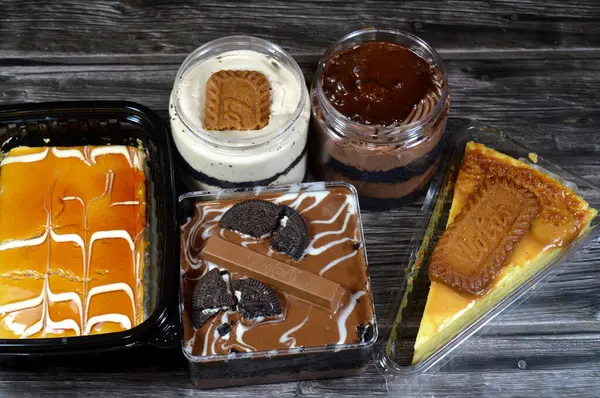 Kahire, Mısır, 8 Haziran 2025: Peynirli kek, kremalı çikolata ve şekerli bisküvi, krem şantili krema, Kitkat çikolatası, Oreo sandviç kurabiyesi, Lotus bisküvisi, süt sütü sütü sütü sütü sütü sütü