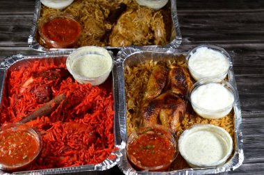 Tandoori sulu tavuk, kızarmış tavuk ve orijinali ve renkli Basmati pilavı özel baharat, Daqos, yoğurt salatası ve sütlü sütlü sütlü puding karışımı bir düdüklü tencerede pişirilmiş.