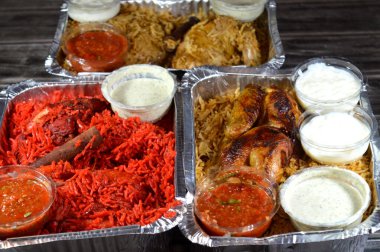 Tandoori sulu tavuk, kızarmış tavuk ve orijinali ve renkli Basmati pilavı özel baharat, Daqos, yoğurt salatası ve sütlü sütlü sütlü puding karışımı bir düdüklü tencerede pişirilmiş.