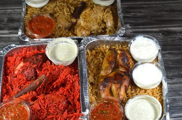 Tandoori sulu tavuk, kızarmış tavuk ve orijinali ve renkli Basmati pilavı özel baharat, Daqos, yoğurt salatası ve sütlü sütlü sütlü puding karışımı bir düdüklü tencerede pişirilmiş.