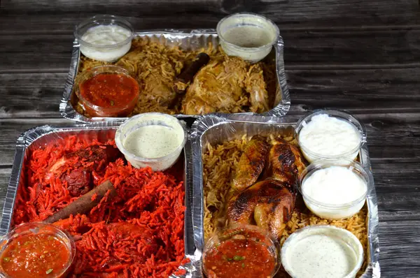 Tandoori sulu tavuk, kızarmış tavuk ve orijinali ve renkli Basmati pilavı özel baharat, Daqos, yoğurt salatası ve sütlü sütlü sütlü puding karışımı bir düdüklü tencerede pişirilmiş.